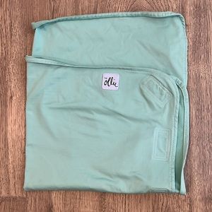 The Ollie swaddle in a mint green. Can fit any size.